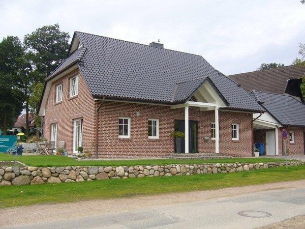 Einfamilienhaus aus rotem Klinker mit Vordach und Gaube