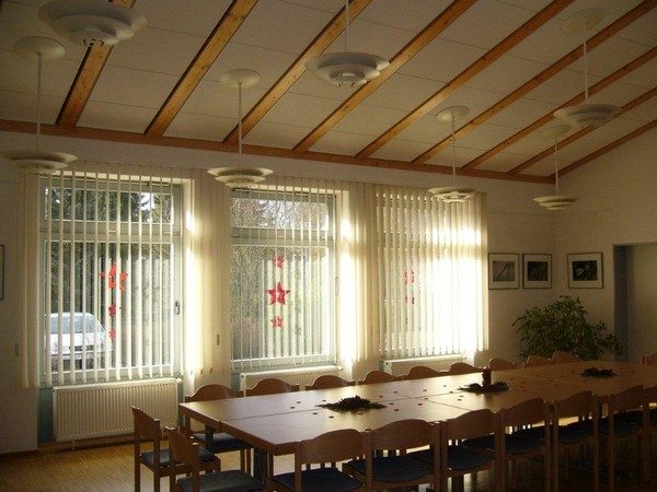 Seminarraum mit Holzbalkendecke und langen Tischen