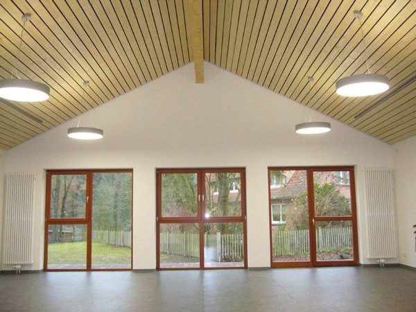 Heller Saal mit Holzdecke und großen Fenstertüren
